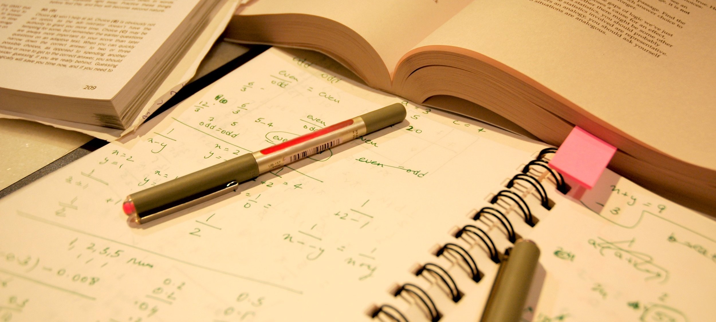 Study desk with books, notes, and pens, reflecting focused exam preparation.